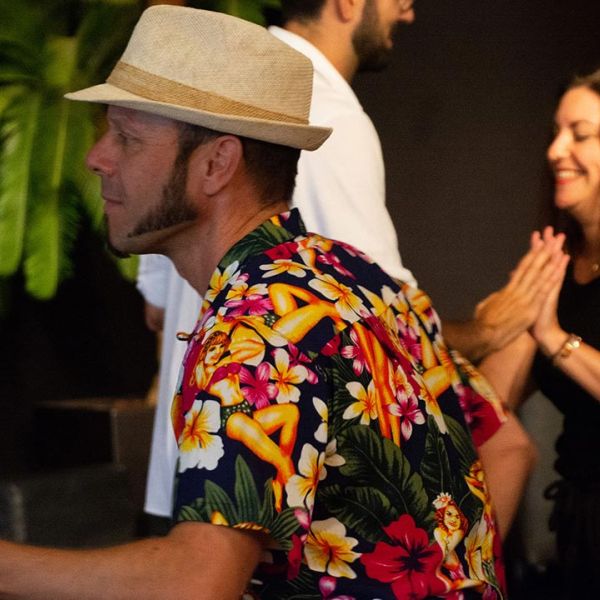 Tanzende Pärchen, Mann hat ein auffällig gemustertes Hemd und Hut an