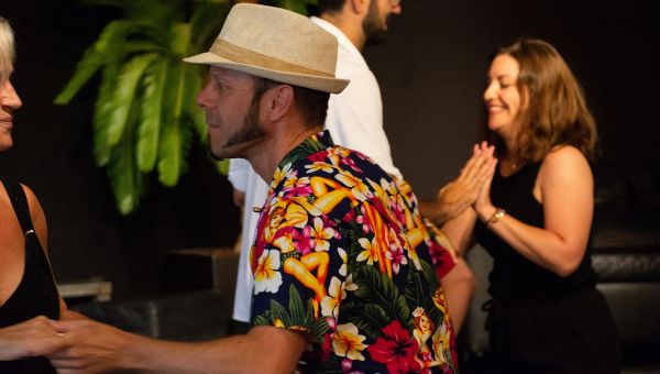 Tanzende Pärchen, Mann hat ein auffällig gemustertes Hemd und Hut an