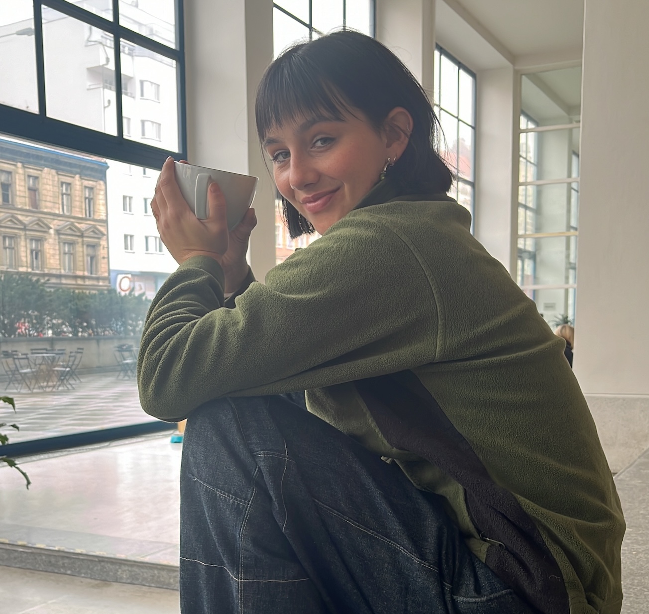 Junge Frau mit einem grünen T-Shirt welche einen machata trinkt